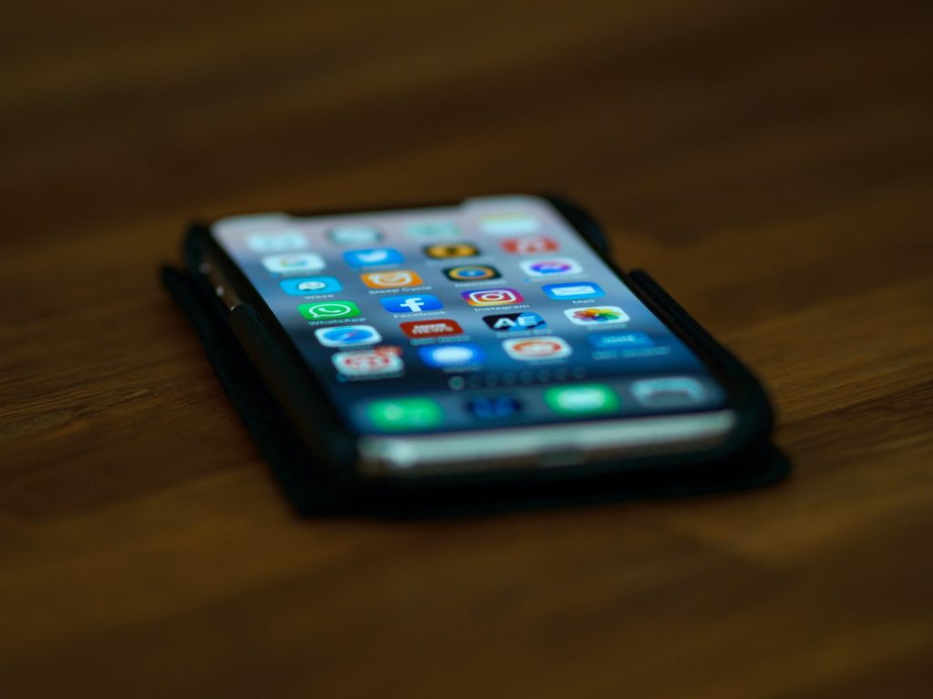 black iphone 4 on brown wooden table